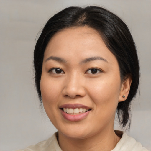 Joyful asian young-adult female with medium  black hair and brown eyes