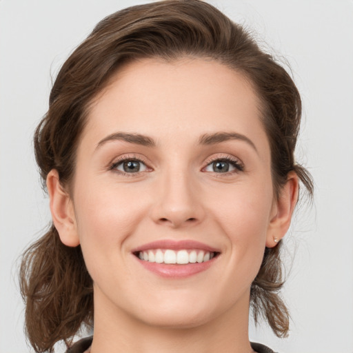 Joyful white young-adult female with medium  brown hair and grey eyes