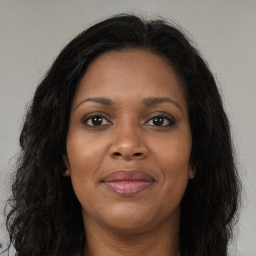 Joyful black young-adult female with long  brown hair and brown eyes