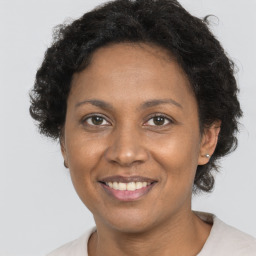 Joyful black adult female with short  brown hair and brown eyes