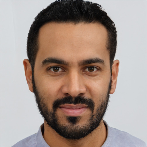 Joyful latino young-adult male with short  black hair and brown eyes