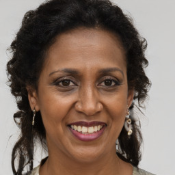 Joyful black adult female with long  brown hair and brown eyes