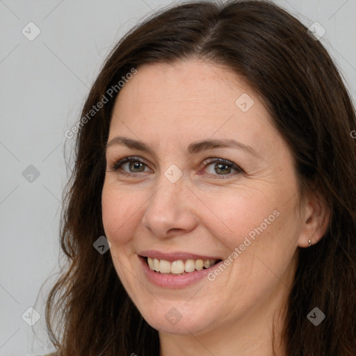 Joyful white adult female with long  brown hair and brown eyes