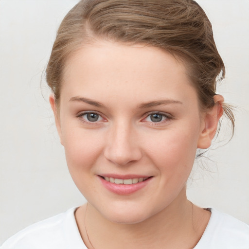 Joyful white young-adult female with medium  brown hair and blue eyes