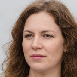 Joyful white adult female with long  brown hair and brown eyes