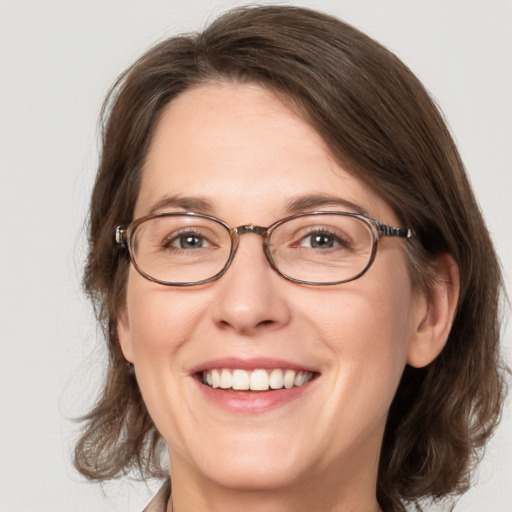 Joyful white adult female with medium  brown hair and blue eyes