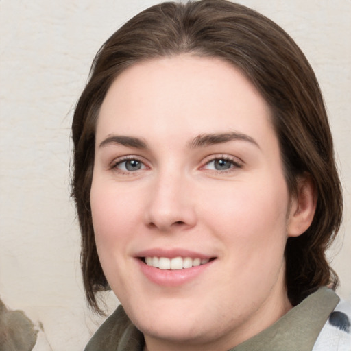 Joyful white young-adult female with medium  brown hair and green eyes