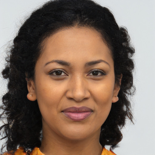 Joyful black young-adult female with long  brown hair and brown eyes