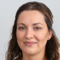 Joyful white adult female with long  brown hair and brown eyes