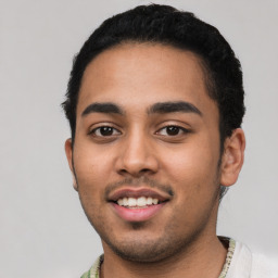 Joyful latino young-adult male with short  black hair and brown eyes