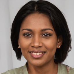 Joyful black young-adult female with medium  brown hair and brown eyes