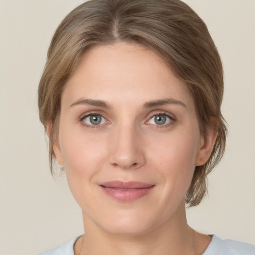 Joyful white young-adult female with medium  brown hair and grey eyes