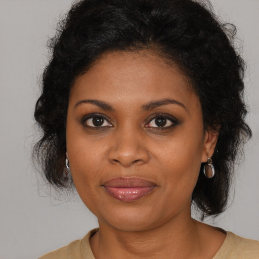 Joyful black young-adult female with long  brown hair and brown eyes