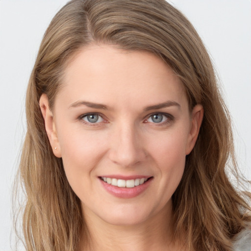 Joyful white young-adult female with long  brown hair and grey eyes