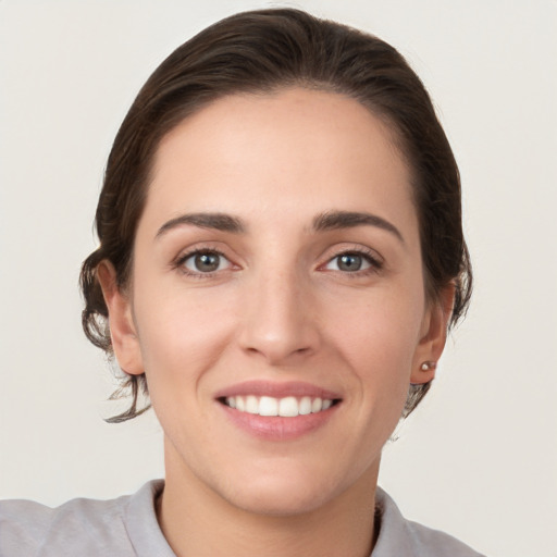 Joyful white young-adult female with short  brown hair and grey eyes