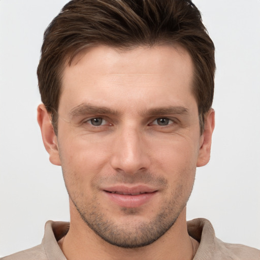 Joyful white young-adult male with short  brown hair and grey eyes