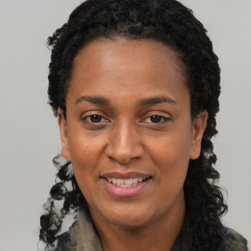 Joyful black adult female with long  black hair and brown eyes