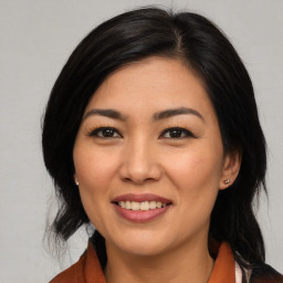 Joyful asian young-adult female with medium  black hair and brown eyes