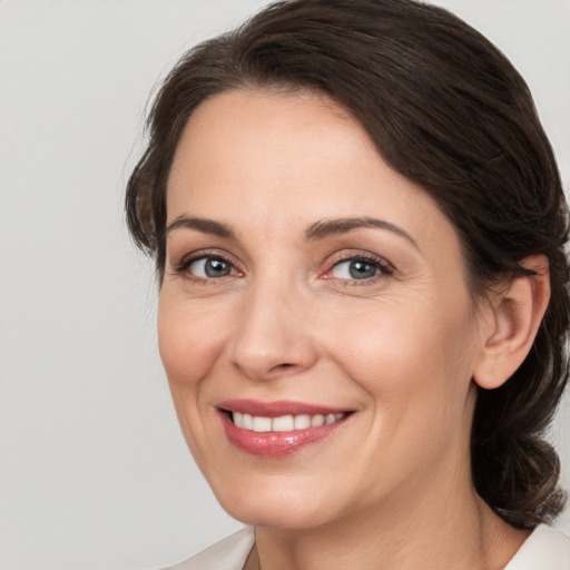 Joyful white adult female with medium  brown hair and brown eyes