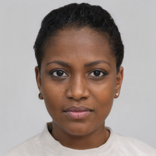 Joyful black young-adult female with short  black hair and brown eyes