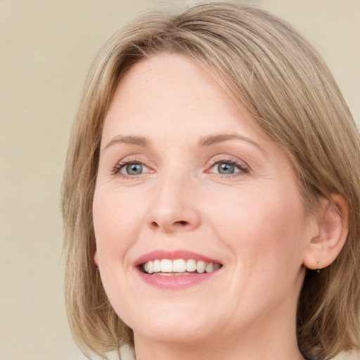 Joyful white young-adult female with medium  brown hair and blue eyes