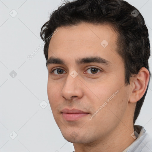 Joyful white young-adult male with short  black hair and brown eyes