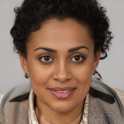 Joyful black young-adult female with short  brown hair and brown eyes