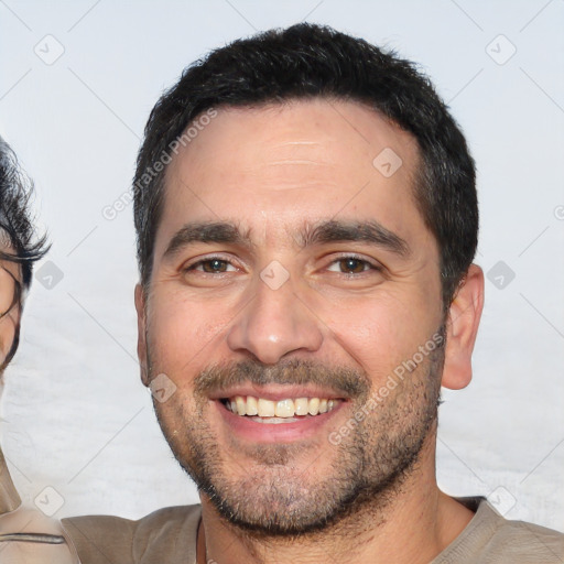 Joyful white young-adult male with short  black hair and brown eyes