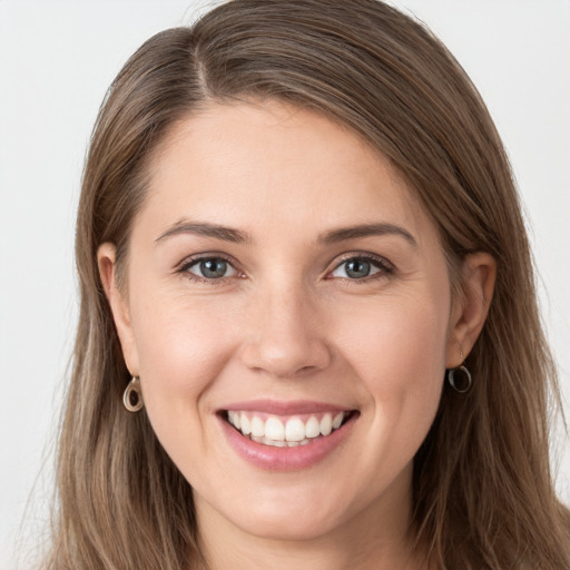 Joyful white young-adult female with long  brown hair and grey eyes