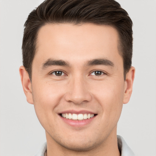 Joyful white young-adult male with short  brown hair and brown eyes