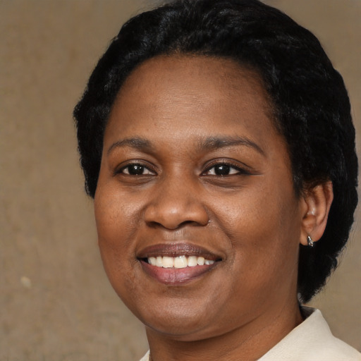 Joyful black adult female with short  black hair and brown eyes