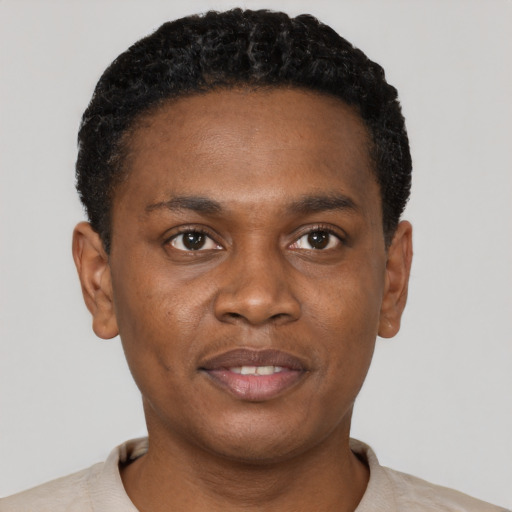 Joyful black young-adult male with short  black hair and brown eyes