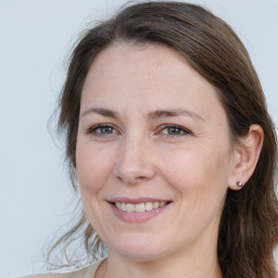 Joyful white adult female with long  brown hair and brown eyes