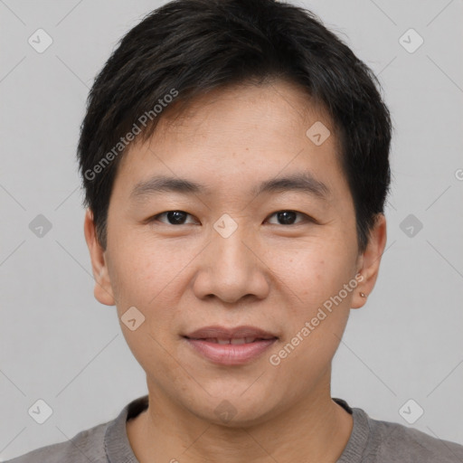 Joyful asian young-adult male with short  black hair and brown eyes