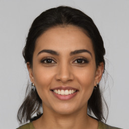 Joyful latino young-adult female with long  brown hair and brown eyes