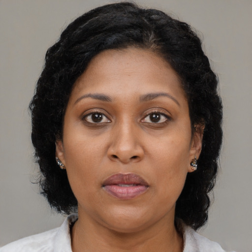 Joyful black adult female with medium  brown hair and brown eyes