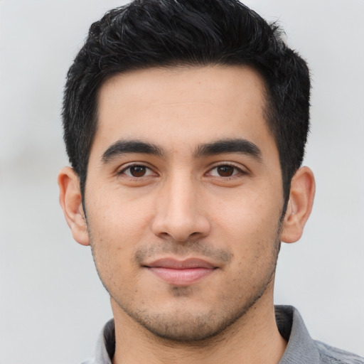 Joyful latino young-adult male with short  black hair and brown eyes