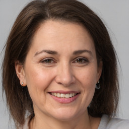 Joyful white adult female with medium  brown hair and brown eyes