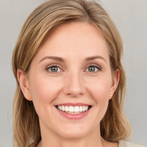 Joyful white young-adult female with long  brown hair and green eyes