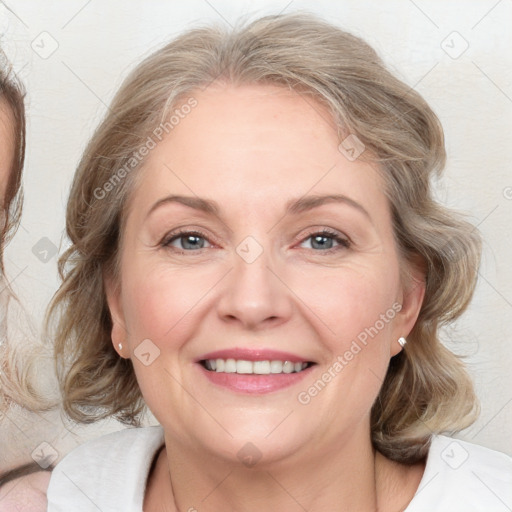 Joyful white adult female with medium  brown hair and blue eyes