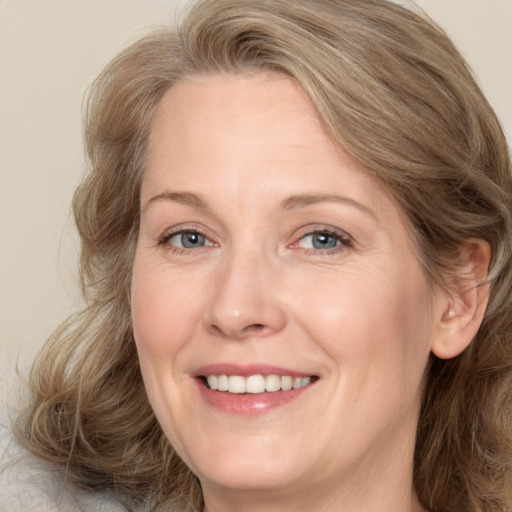 Joyful white adult female with medium  brown hair and green eyes