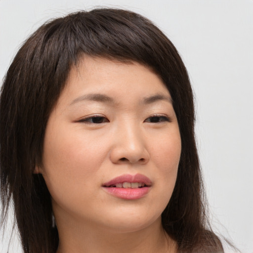 Joyful asian young-adult female with long  brown hair and brown eyes