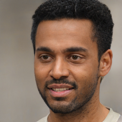 Joyful black young-adult male with short  black hair and brown eyes