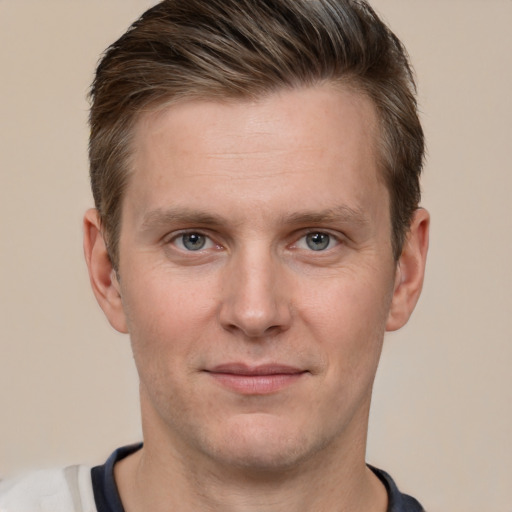 Joyful white young-adult male with short  brown hair and grey eyes