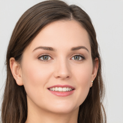 Joyful white young-adult female with long  brown hair and grey eyes