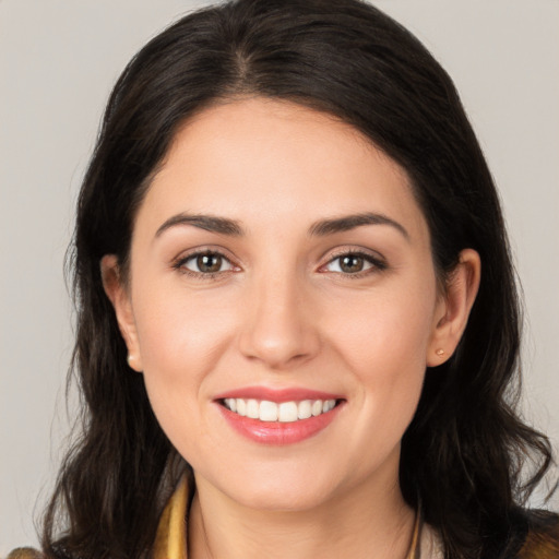 Joyful white young-adult female with long  brown hair and brown eyes