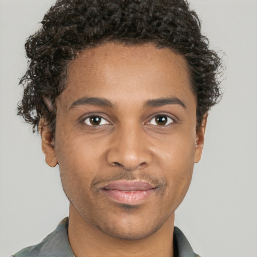 Joyful black young-adult male with short  brown hair and brown eyes