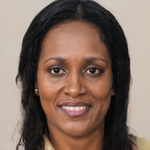Joyful black adult female with long  brown hair and brown eyes