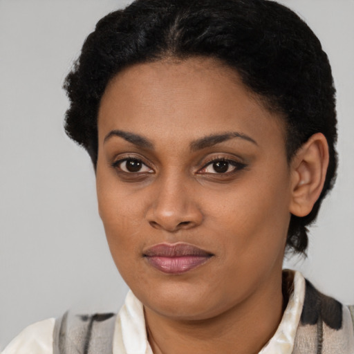 Joyful black young-adult female with short  black hair and brown eyes