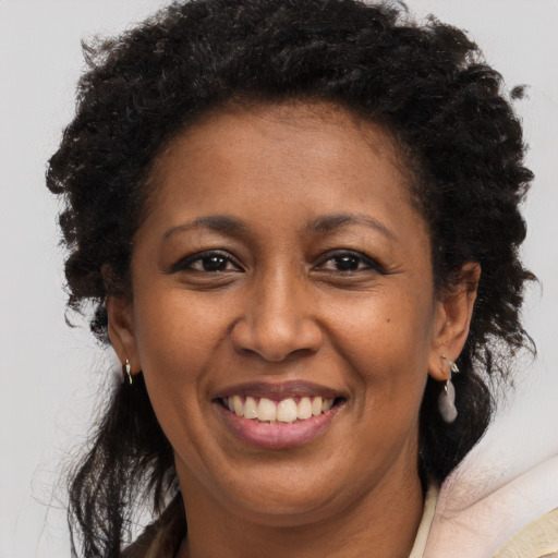 Joyful black adult female with long  brown hair and brown eyes